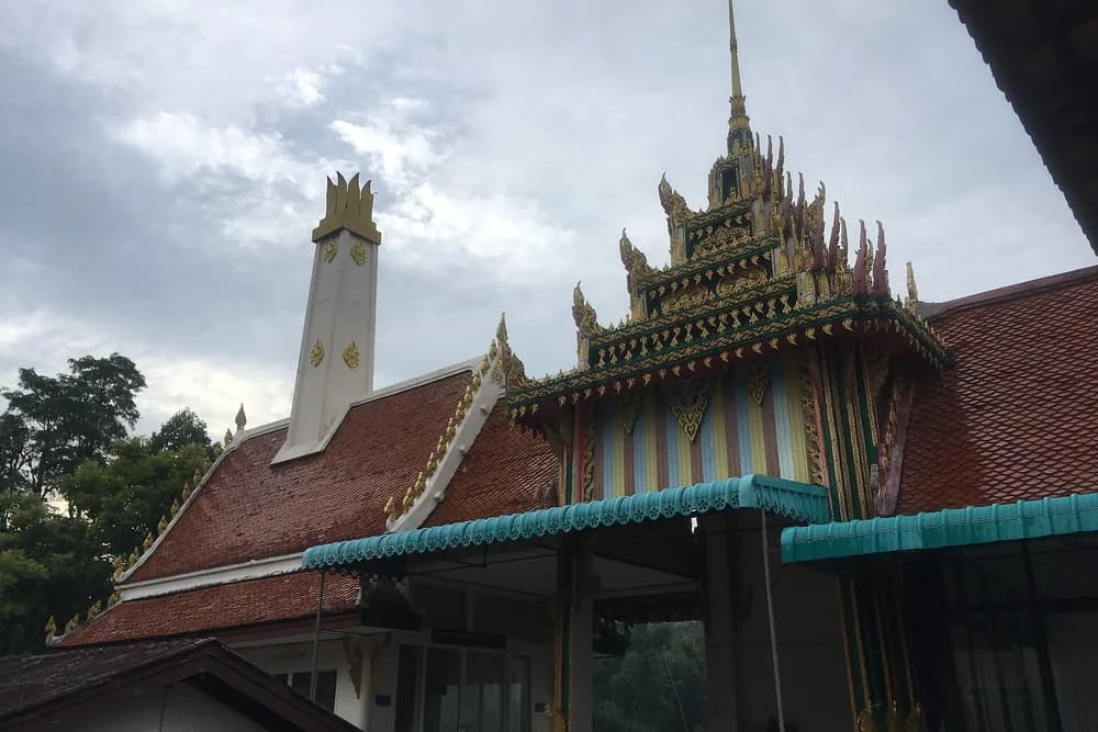 The ornate tiled roof and gilded gable of the temple building at Wat Pho.